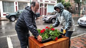 Man helping move flowers