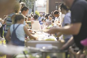 Residents sample a potluck meal in downtown Meadville, Pennsylvania. The event, which drew hundreds, was a celebration of the city's Community Heart & Soul project, My Meadville, on 7-27-18. Image credit: Shannon Roae, The Meadville Tribune.