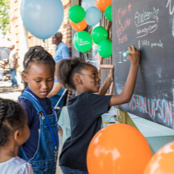 Girls writing on chalkboard at Heart & Soul event