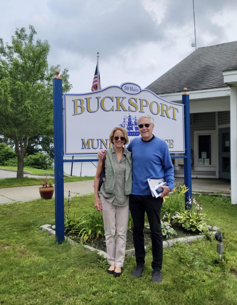 Deb and Jim Fallows in front of Bucksport Maine town sign