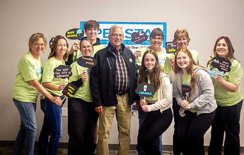 Image of group of Peosta Community Heart & Soul team members and youth volunteers wearing same t shirt with logo at Community Summit Open House event.