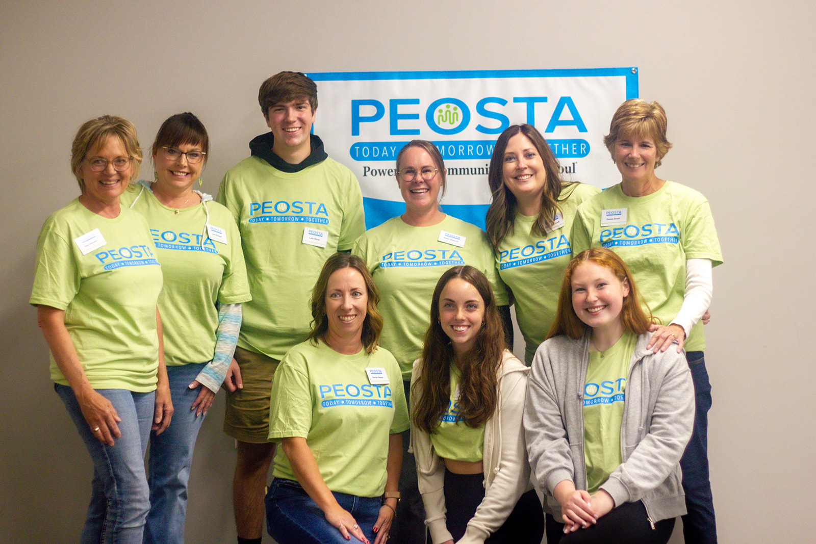 Image of group of Peosta Community Heart & Soul team members and youth volunteers wearing same t shirt with logo at Community Summit Open House event.