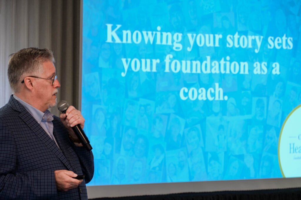 Al Getler sharing the importance of storytelling both for towns and for Coaches via a presentation. The slide reads "Knowing your story sets your foundation as a coach."