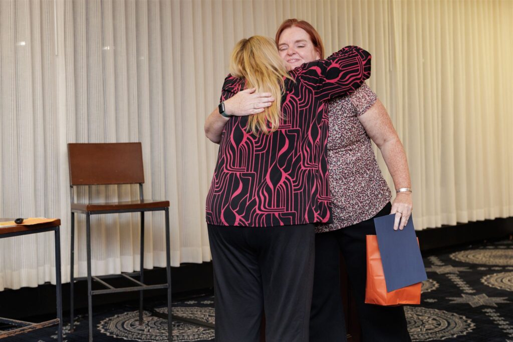 Leanne and Cassie Turner hugging following her congratulations on a new Level 2 Coach Certification.