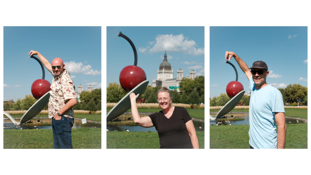 Nolan Gluekert, Michelle Wodtke Franks, and Josh Kaiel exploring the Minneapolis Sculpture Garden at The Walker Art Center, each pretending to hold a large Cherry sculpture in the distance.