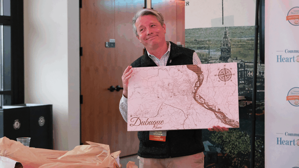 Certified Heart & Soul Coach Jason Neises holding gift of wooden map as he was recognized for his outstanding contributions.