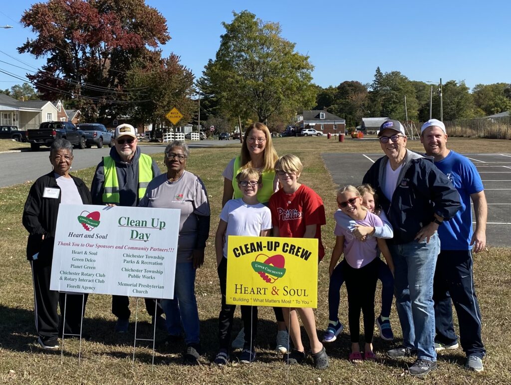 Picture of group of adults and children outside holding a sign that says Clean up crew Heart & Soul in Upper Chichester Pennsylvania